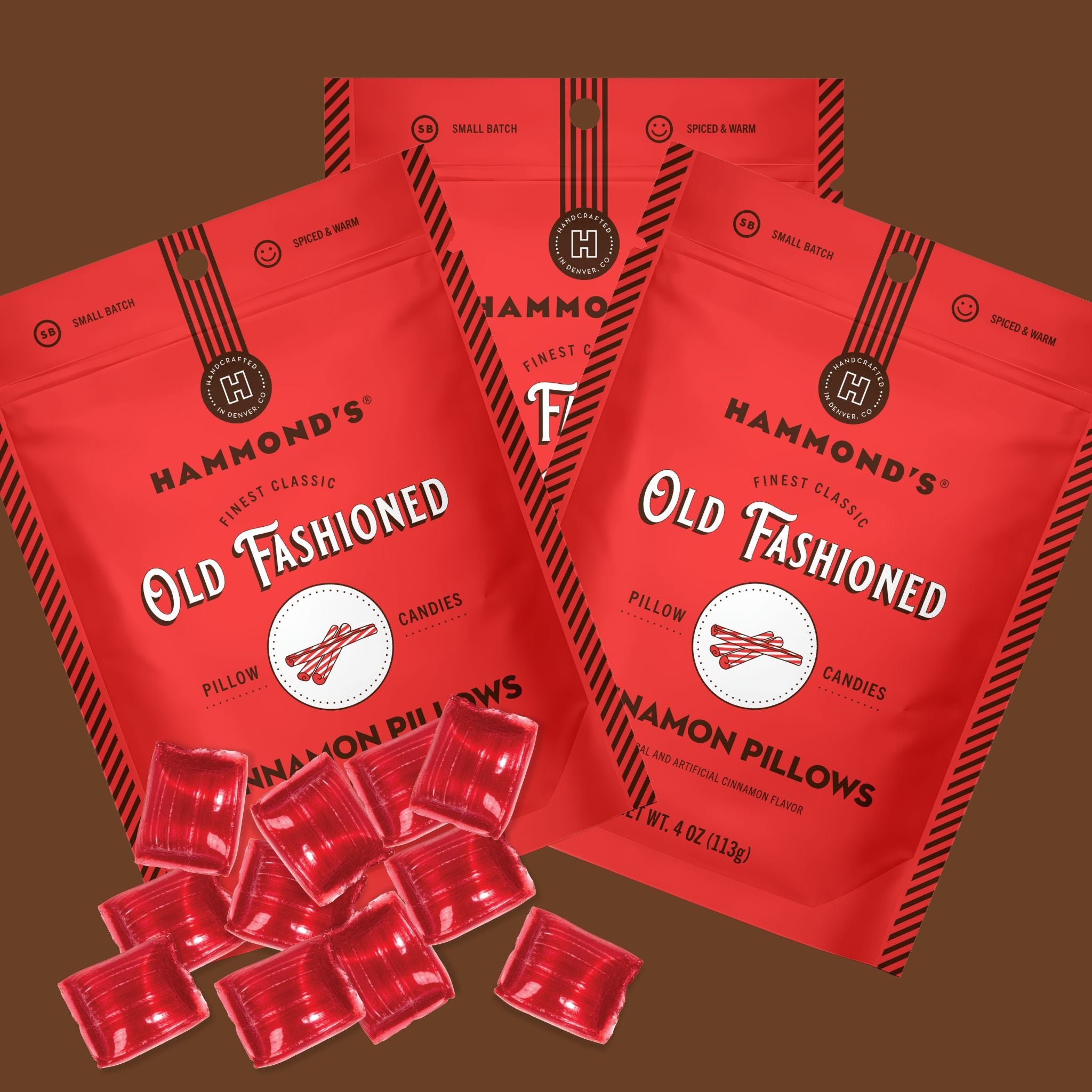 Three red stand-up pouches of Hammond's Old Fashioned Honeycomb Candied Pillows candies are arranged on a brown background, with several individual red candy packets placed in front.
