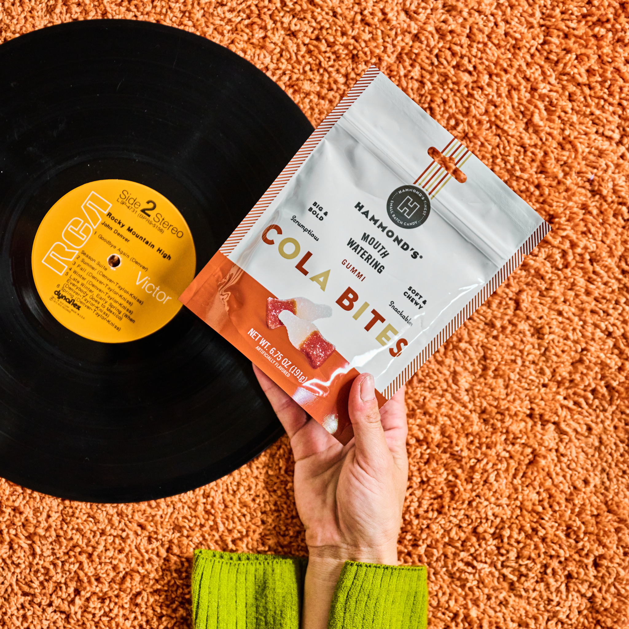 Cola bites next to vinyl record on orange shag carpet