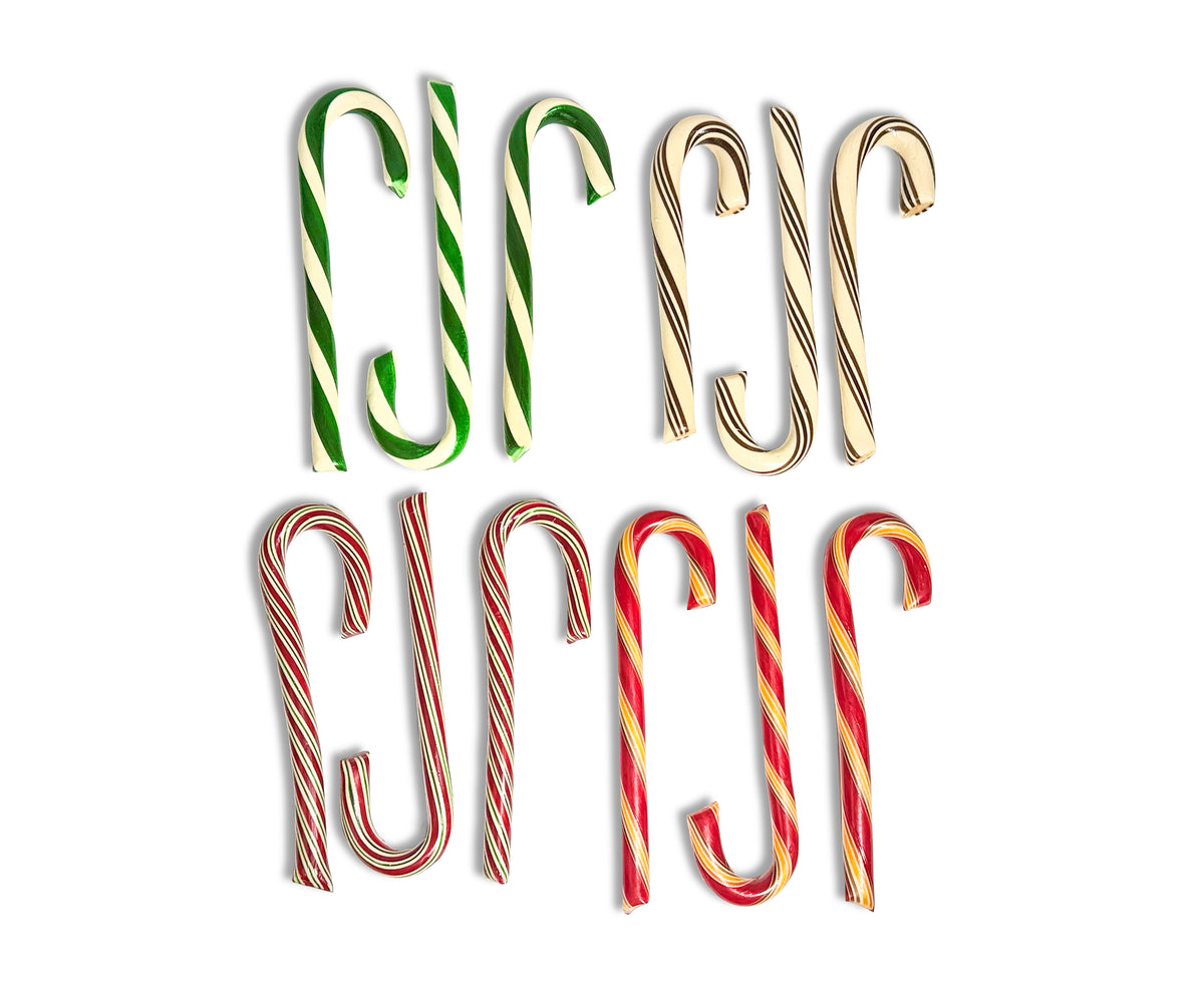 Six candy cane-shaped decorative items arranged in two rows on a plain white background. The top row contains three green-and-white striped canes and the bottom row contains three red-and-white striped canes, with two additional red-and-gold striped canes on the right side.