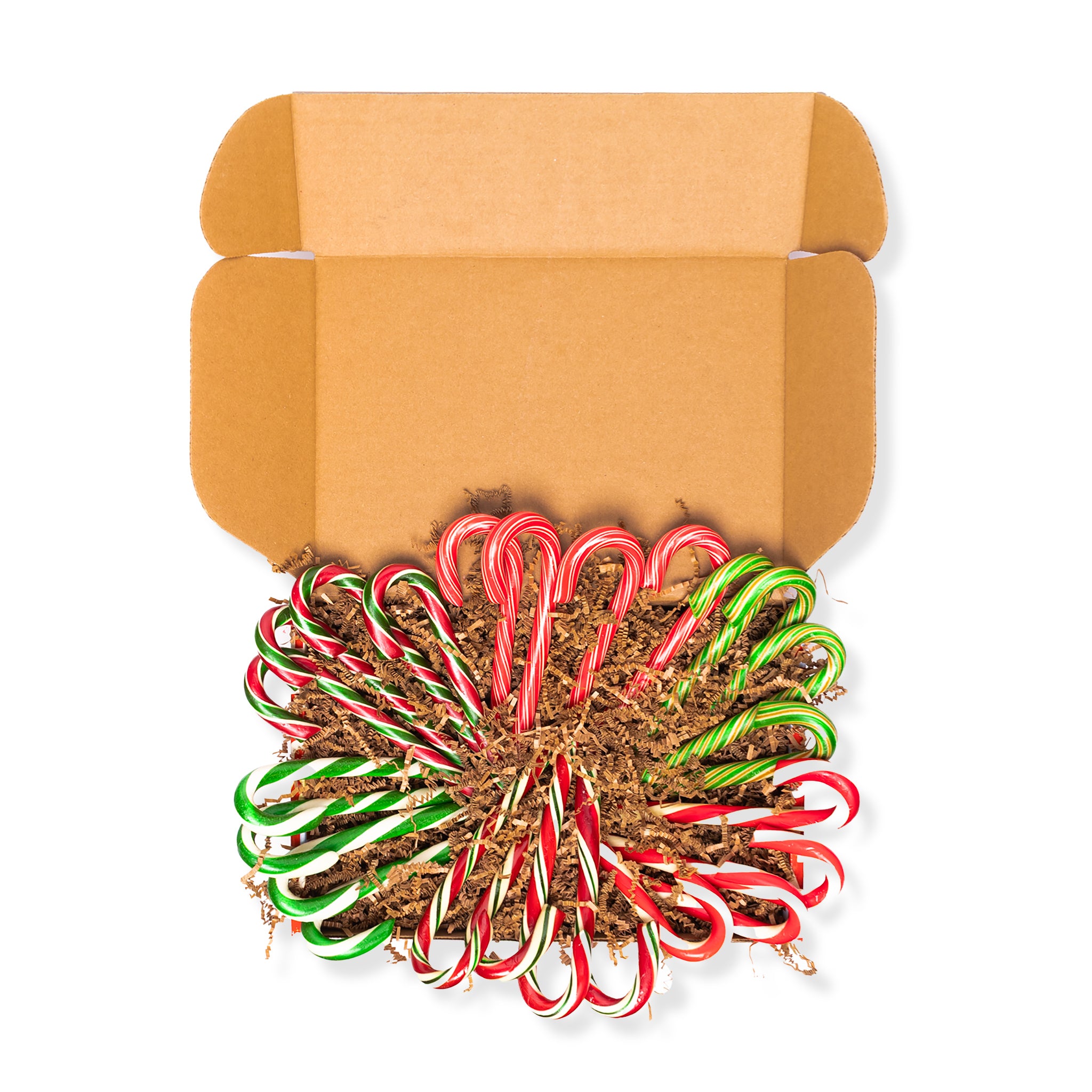 Open cardboard box with a pile of red and green candy canes on a white background